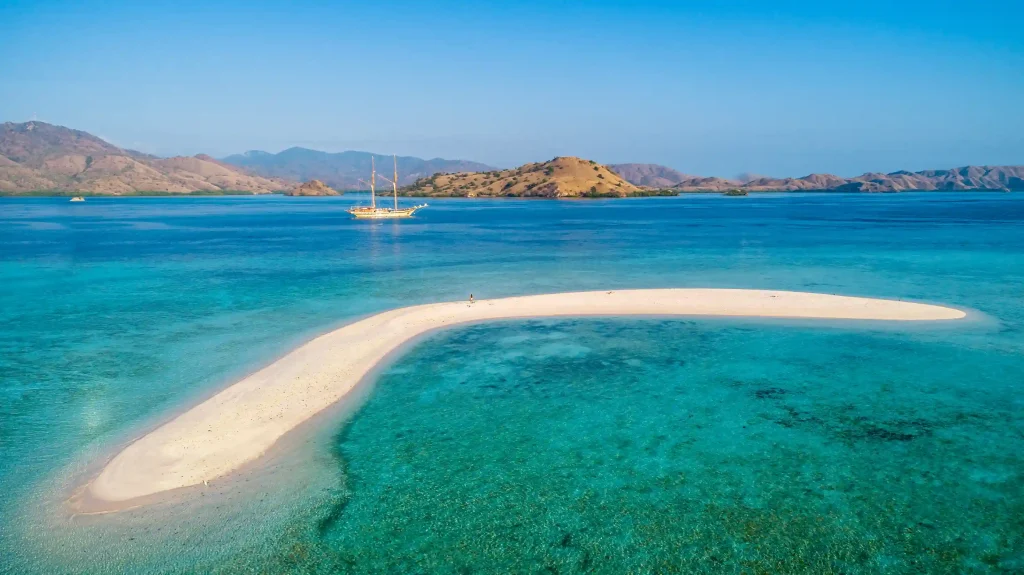 The crescent sandbar of Taka Makassar ringed by reef