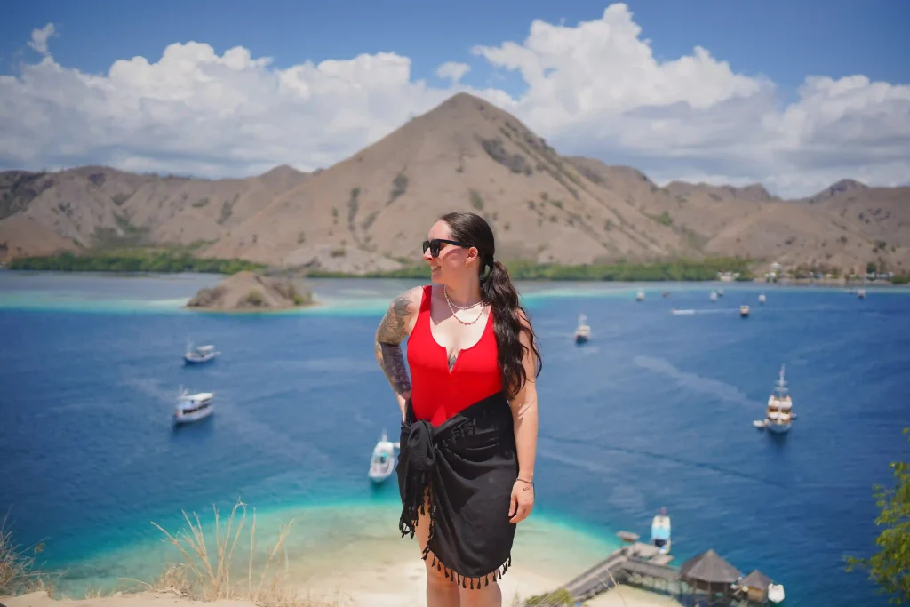 The beach and hill of Kelor Island above turquoise water